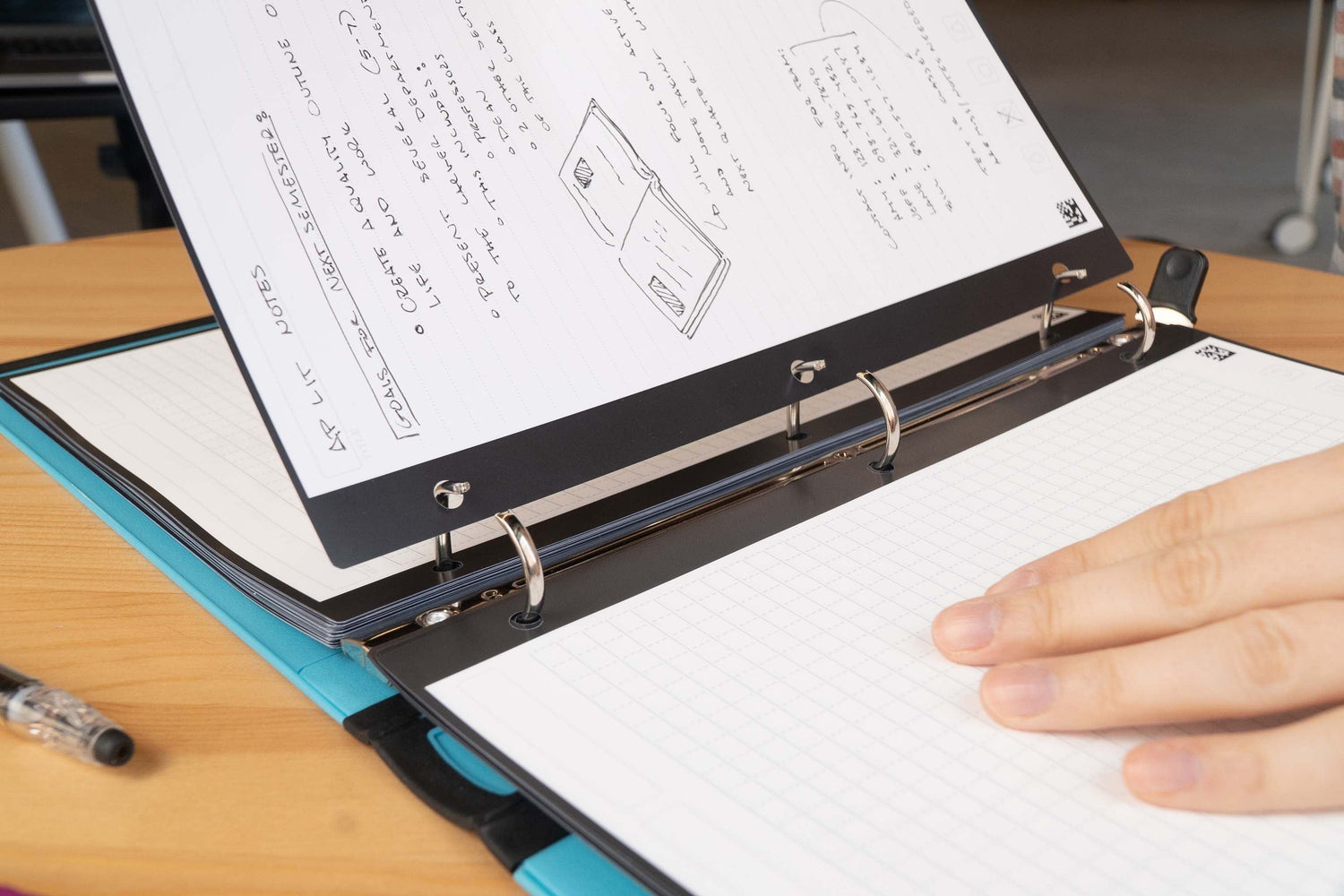 A person removing a sheet of Filler Paper from a 3-ring binder